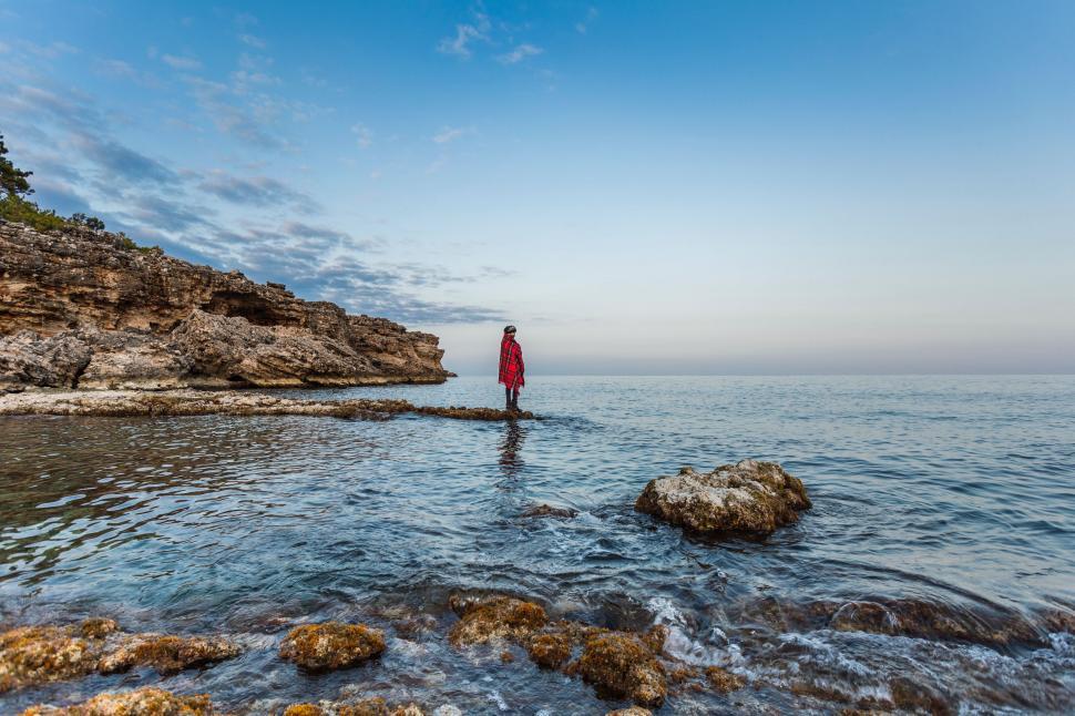 Free Image of Person Standing on Rock in the Middle of Body of Water 