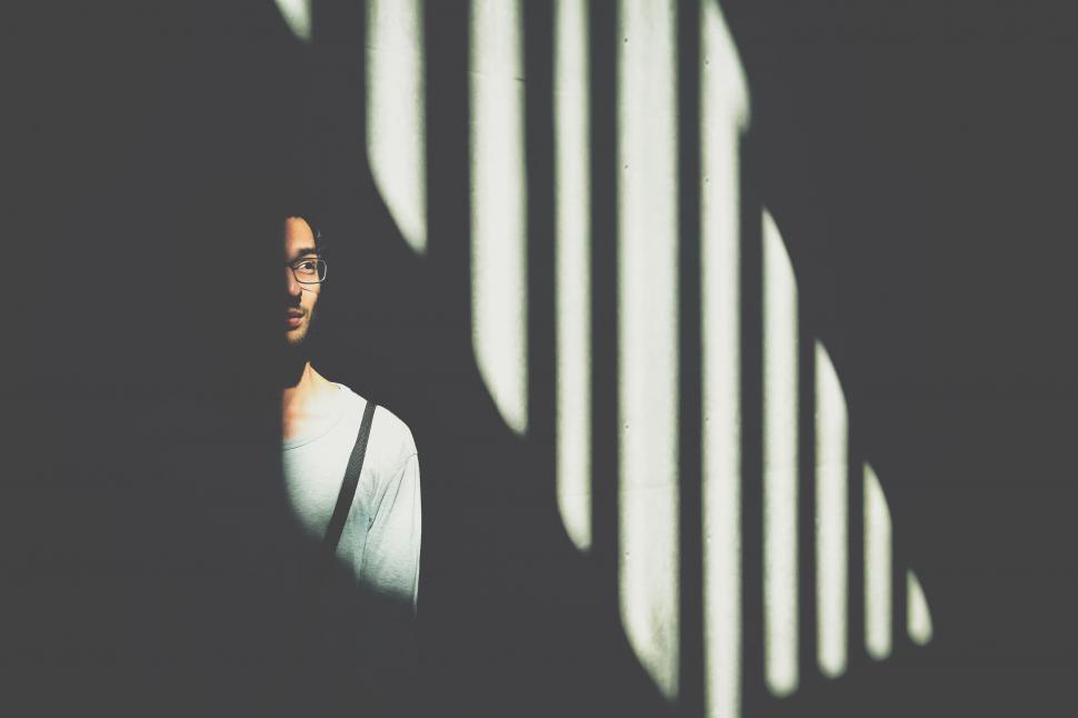 Free Image of Man Standing in Shadows of Wall 