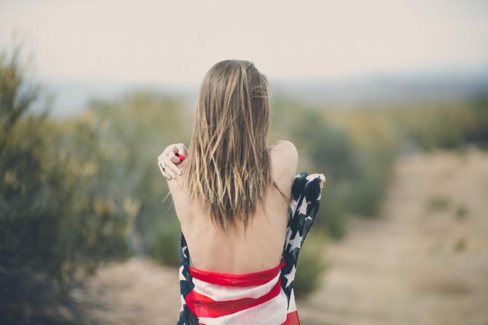 Free Image of Woman in Red, White and Blue Towel on Dirt Road. 