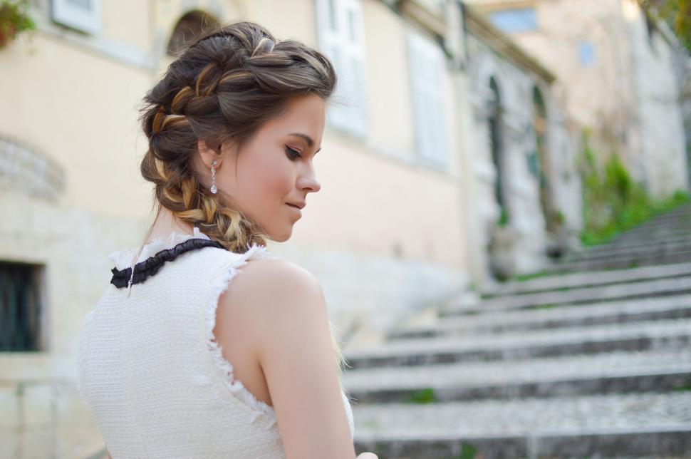 Free Image of Woman in White Dress Standing in Front of Steps 