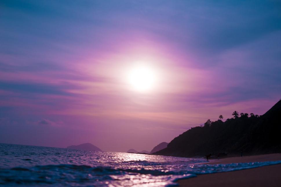 Free Image of The Sun Setting Over the Ocean on the Beach 