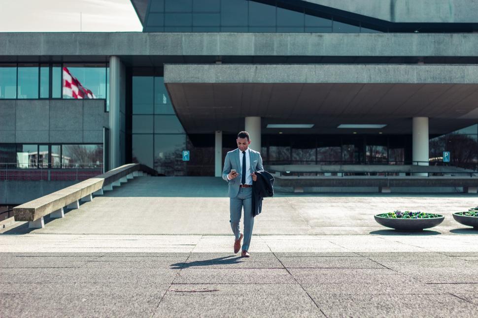 Free Image of Man in Suit Walking in Front of Building 