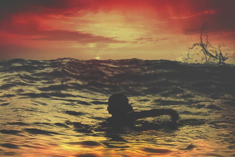 Free Image of Person Swimming in Ocean at Sunset 