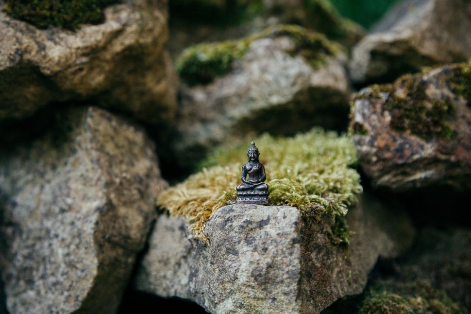 Free Image of Small Buddha Statue Perched on Pile of Rocks 