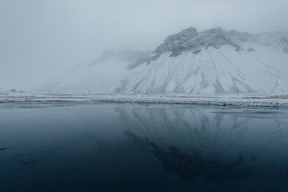 Free Image of Snow-Covered Mountain by a Body of Water 