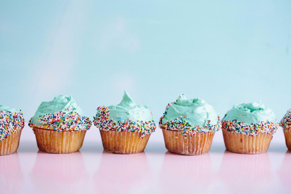 Free Image of Row of Colorful Cupcakes With Frosting and Sprinkles 