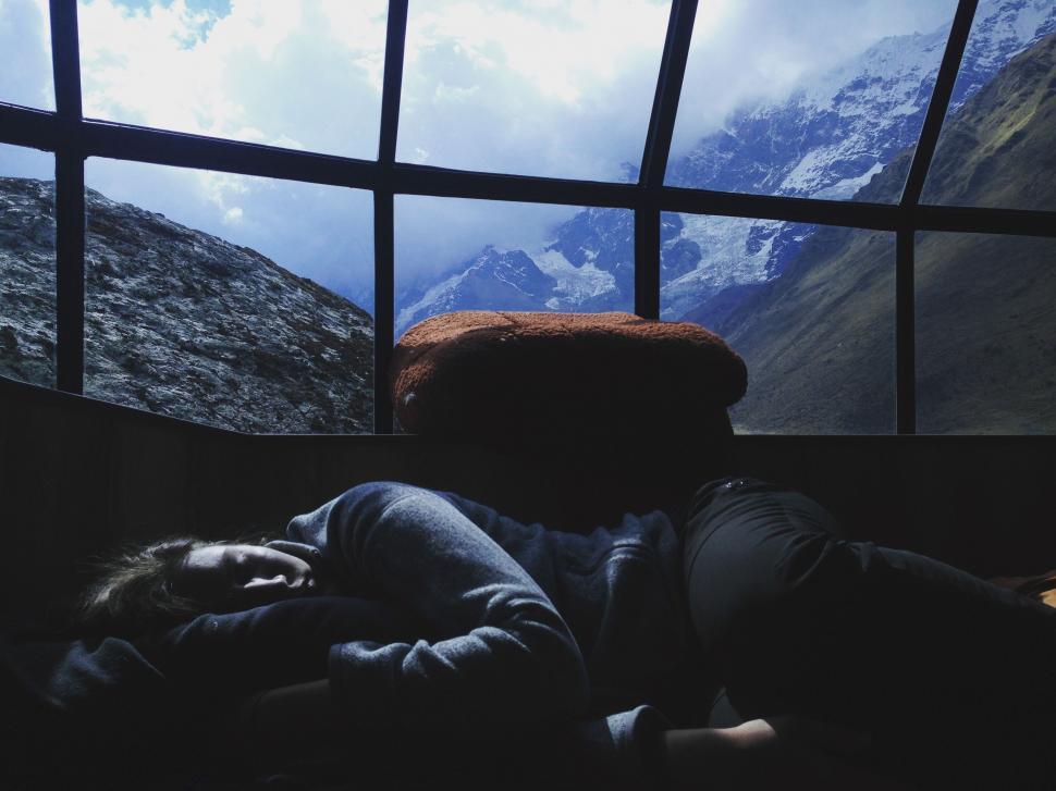 Free Image of Person Laying on Bed in Front of Window 