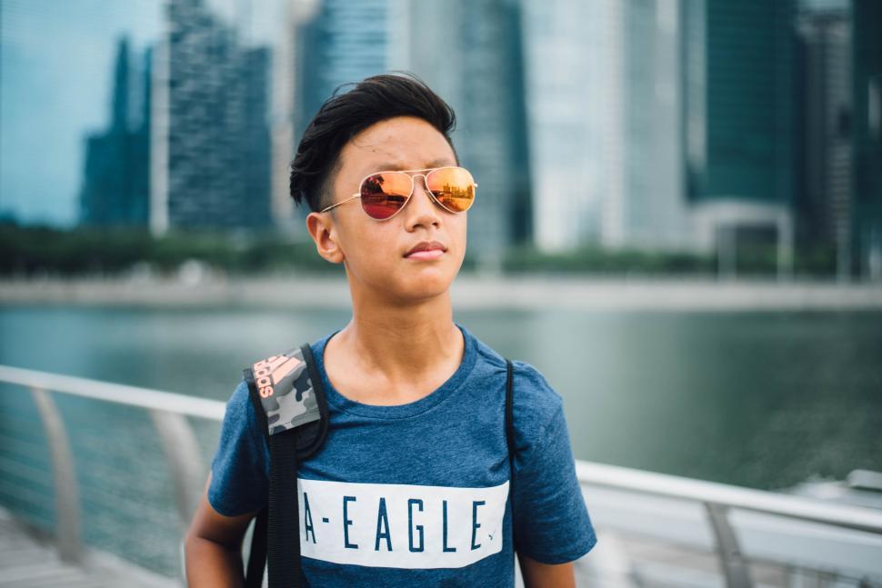 Free Image of Young Boy Wearing Sunglasses and Eagle T-Shirt 