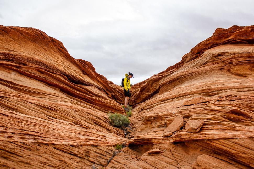 Free Image of Man Standing on Top of Large Rock Formation 