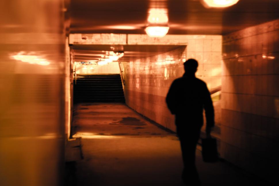 Free Image of Man Walking Down Long Hallway 