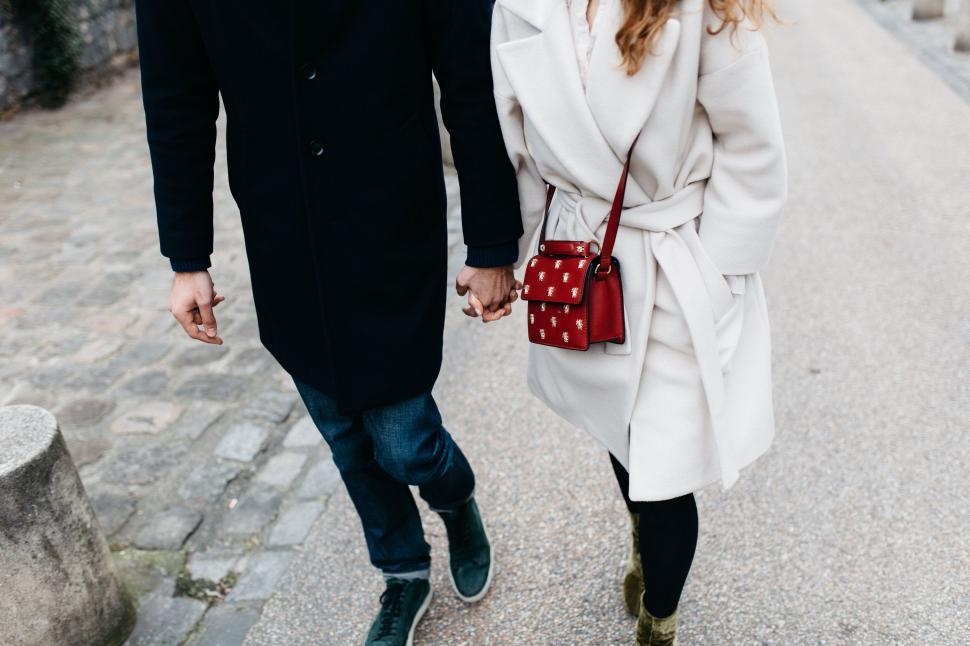 Free Image of Man and Woman Walking Down a Street Holding Hands 