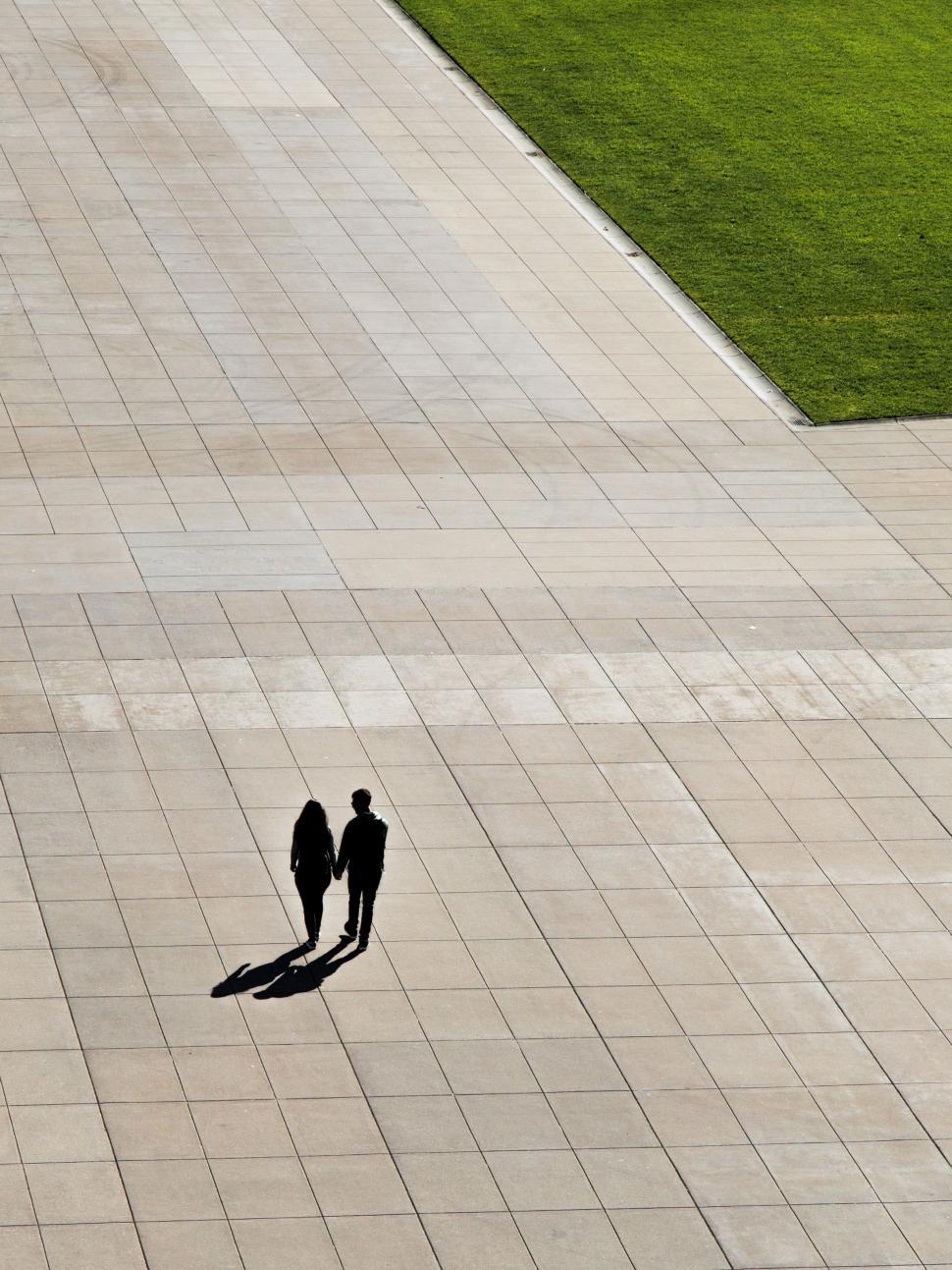 Free Image of Two People Walking Down a Sidewalk 