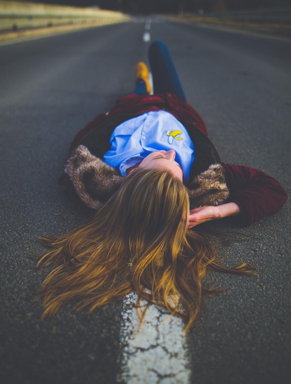 Free Image of Woman Laying on the Side of a Road 
