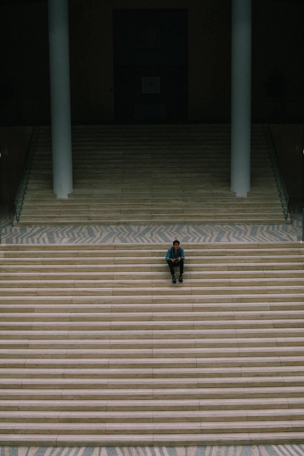 Free Image of Person Sitting on a Set of Stairs 