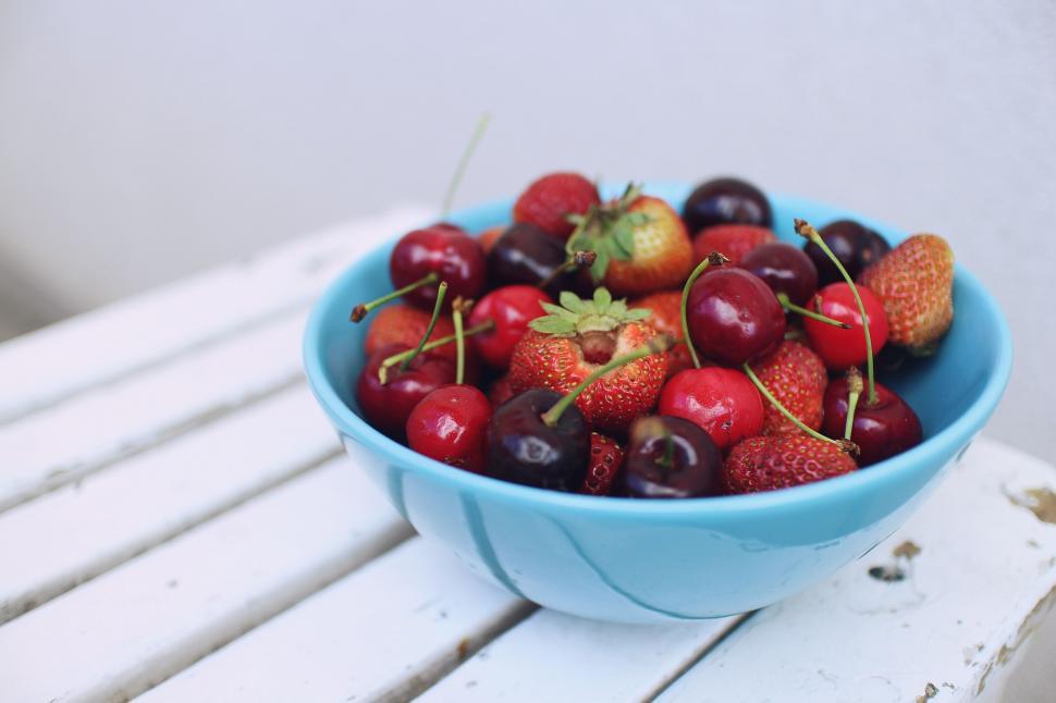 Free Image of Bowl of Cherries and Strawberries on White Bench 