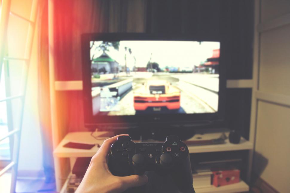 Free Image of Person Holding Game Controller in Front of TV 
