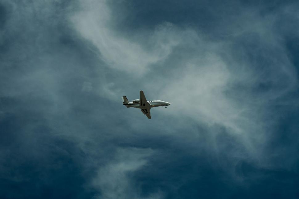 Free Image of Airplane Flying Through Cloudy Sky 