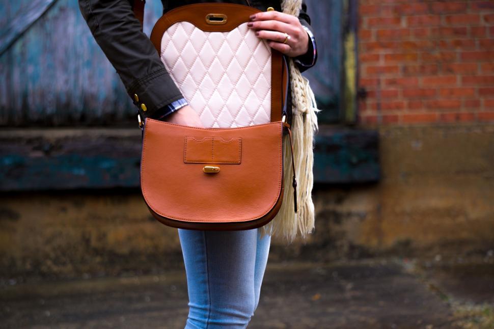 Free Image of Woman Holding Brown and White Purse 