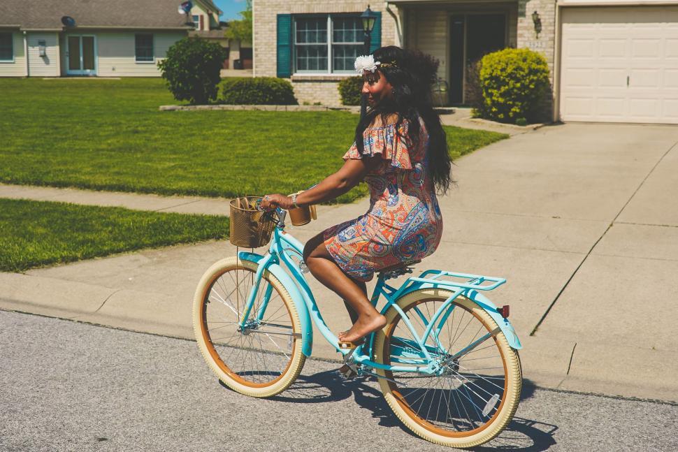 Free Image of Woman Riding Blue Bike Down Street 