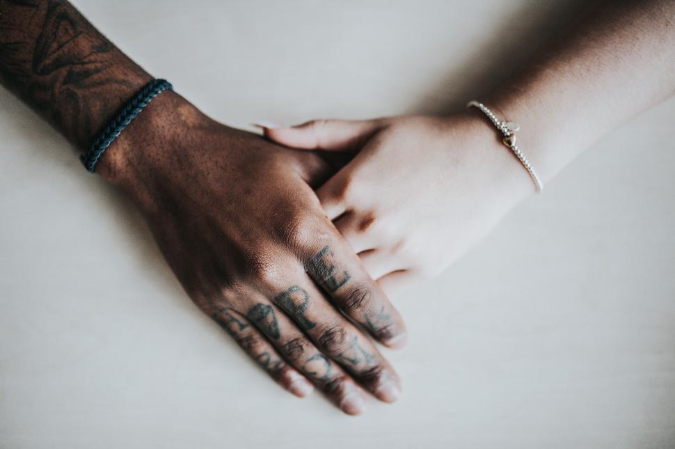 Free Image of A Couple Holding Hands With Tattoos on Their Arms 