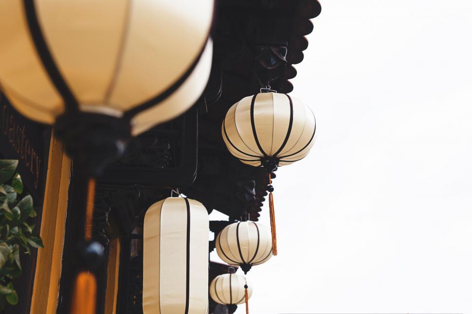 Free Image of Group of White Lanterns Hanging From a Building 