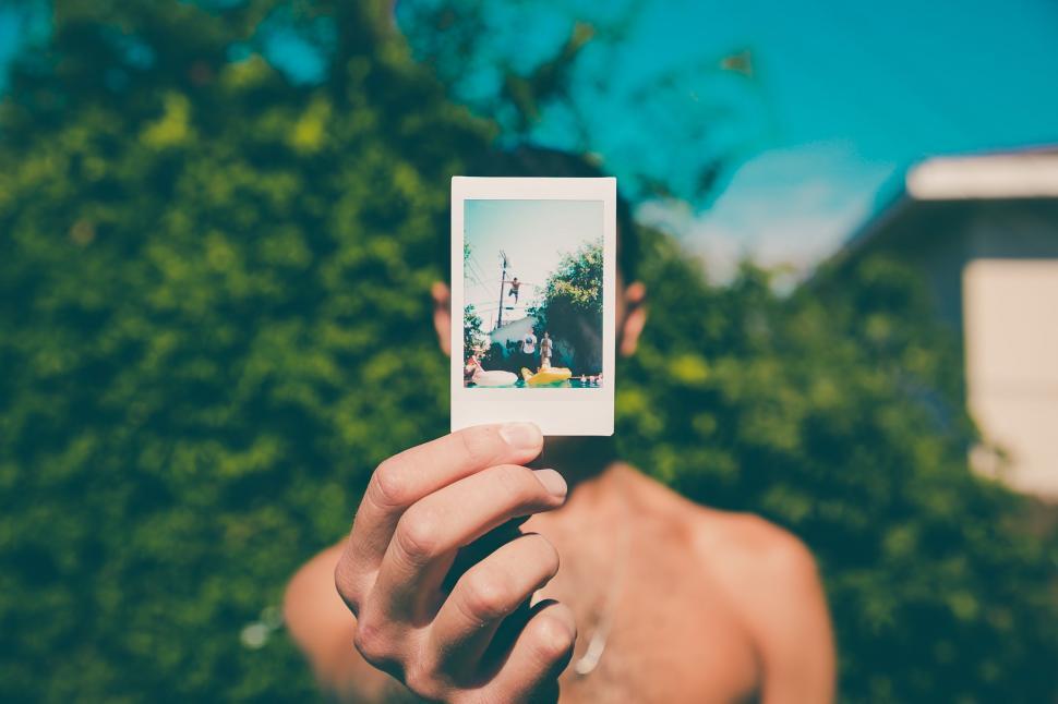 Free Image of Person Holding up a Polaroid in Front of Their Face 