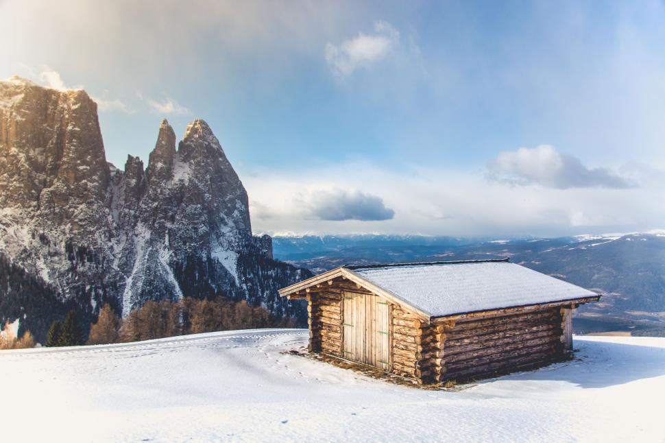 Free Image of A Cabin in the Snow With Mountains in the Background 