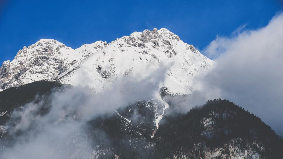 Free Image of Snow-Covered Mountain and Clouds Under Blue Sky 