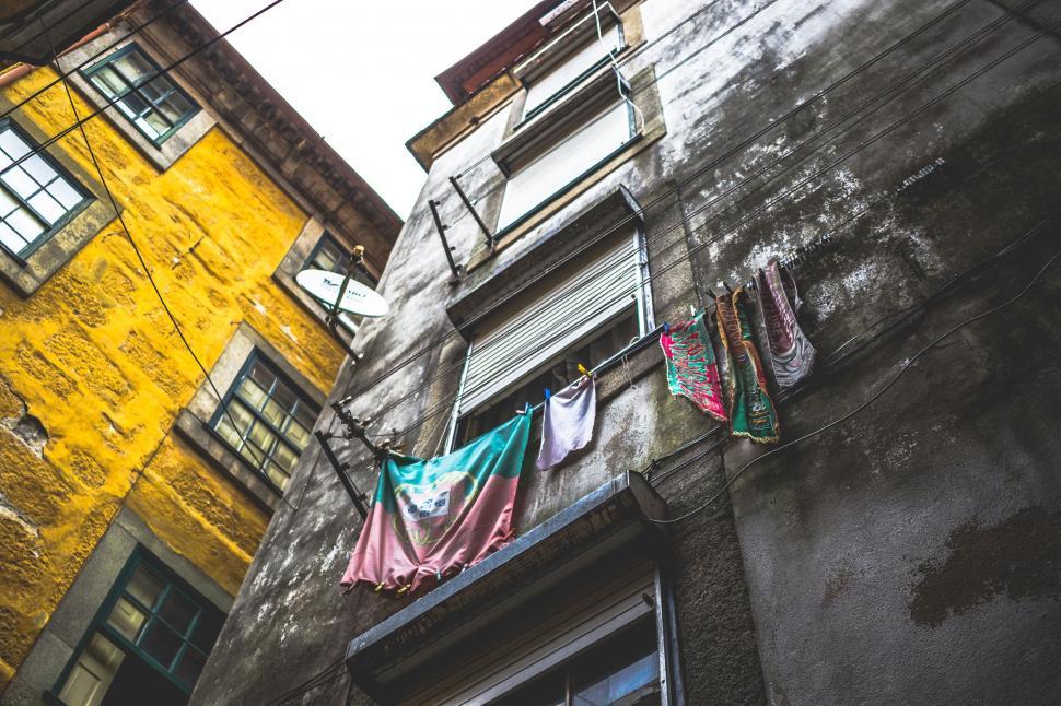 Free Image of Clothes Hanging Out to Dry in Front of Yellow Building 