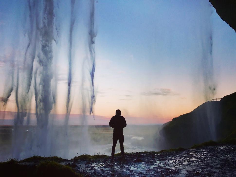 Free Image of Person Standing in Front of a Waterfall 