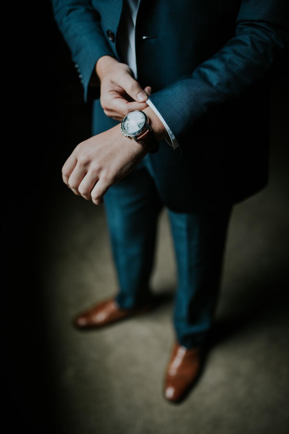 Free Image of Businessman in Suit and Tie Checking Watch 
