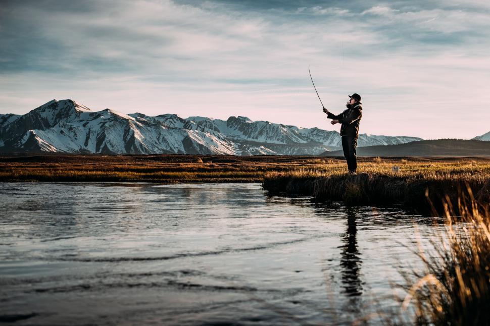 Free Image of Man Holding Fishing Pole on Grass Field 