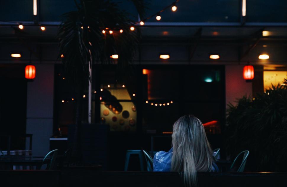 Free Image of Woman Sitting at Table Outside Restaurant 