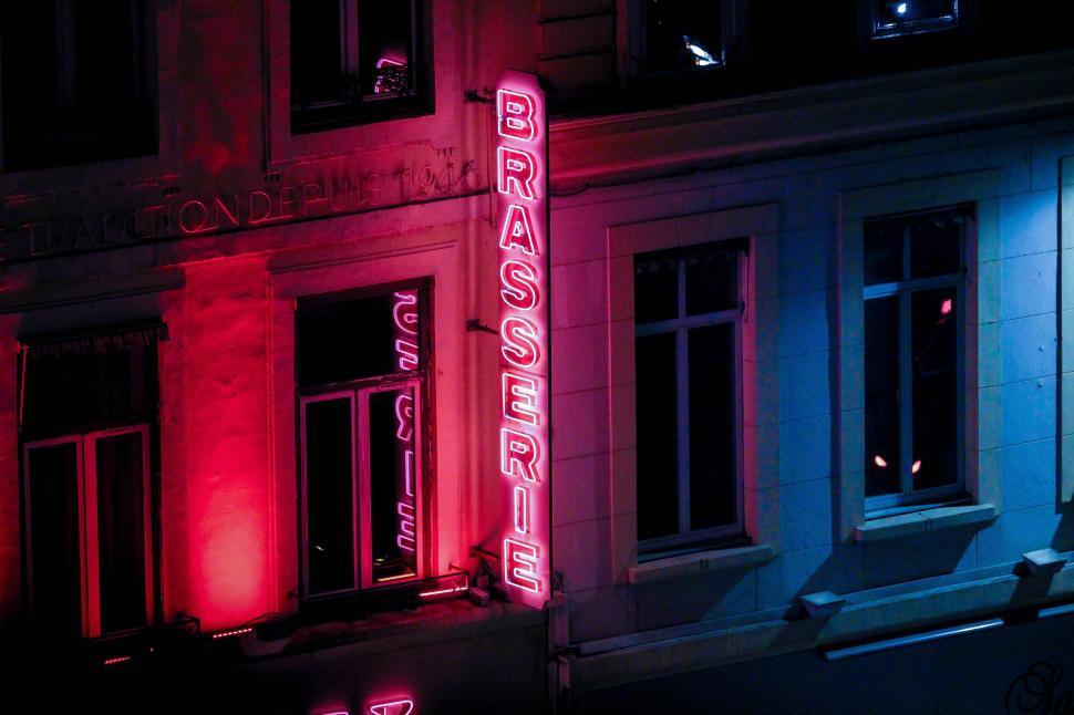 Free Image of Neon Sign Illuminating Side of Urban Building 