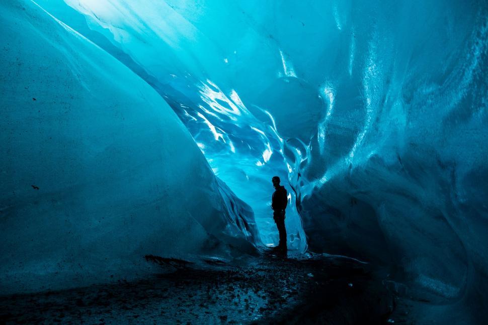 Free Image of Man Standing in a Blue Ice Cave 