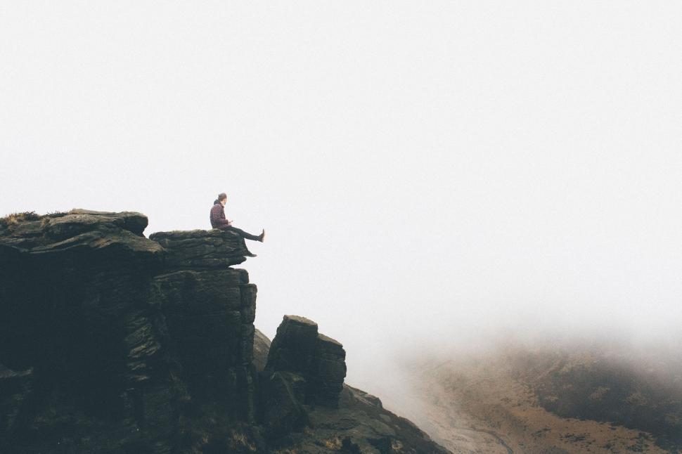 Free Image of Person Sitting on Top of Rocky Cliff 