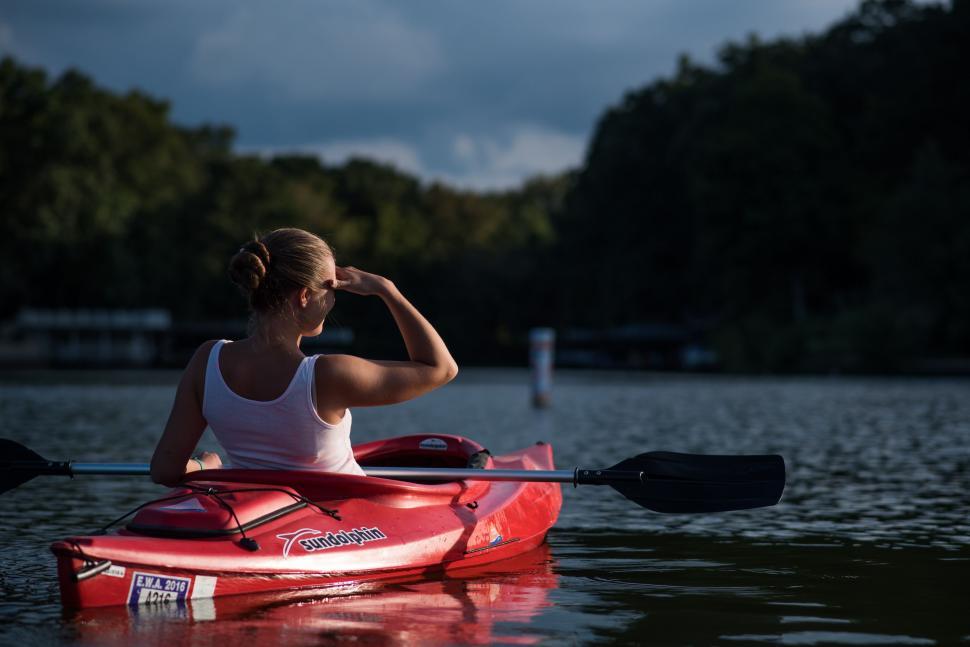 Free Image of Woman Kayaking in Red Kayak on Body of Water 