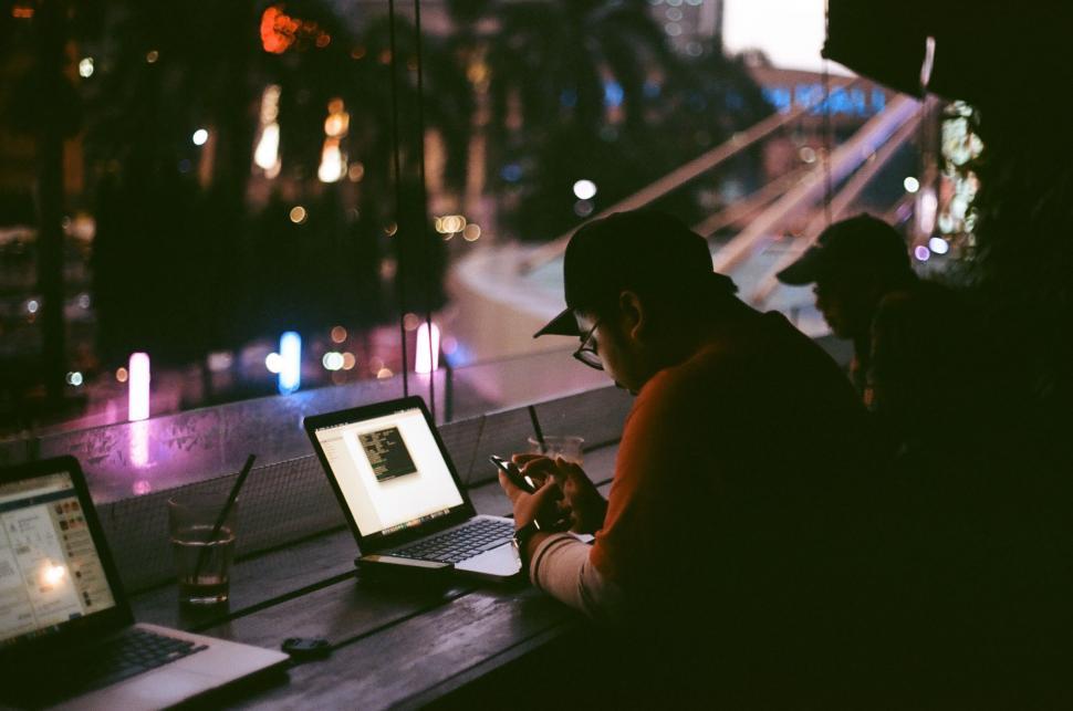 Free Image of Man Sitting at Table Using Laptop Computer 