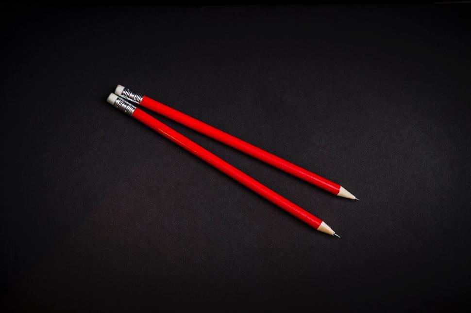 Free Image of Two Red Pencils on Black Surface 
