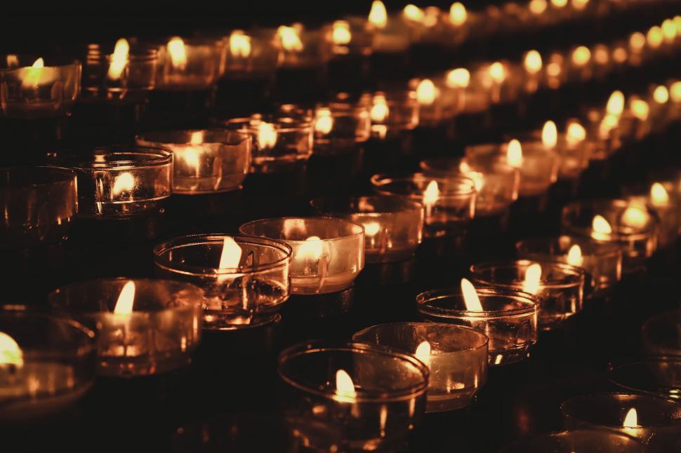 Free Image of Rows of Lit Candles in a Dark Room 