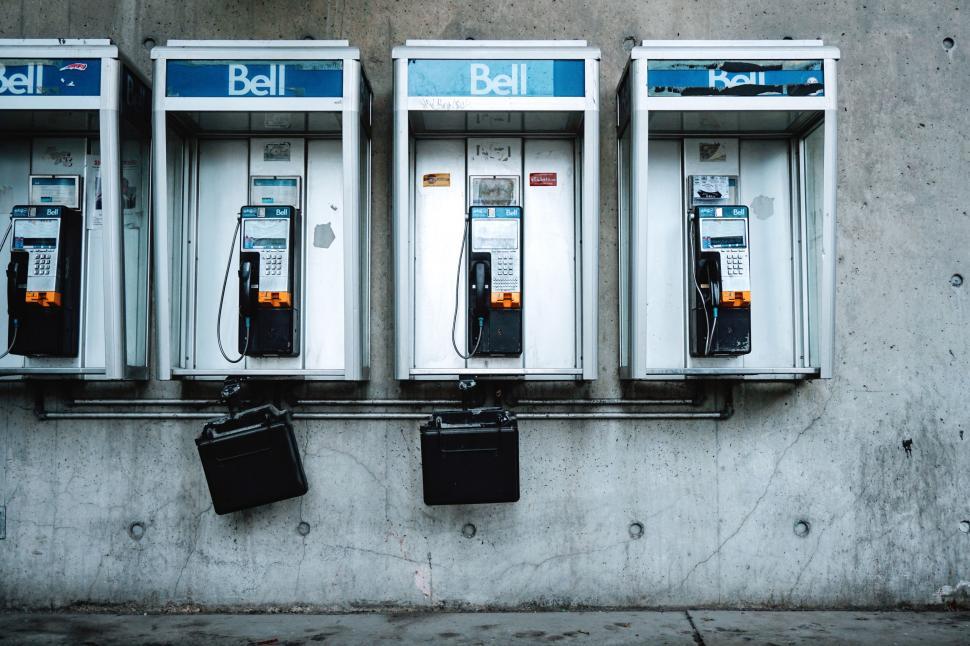 Free Image of Row of Old Fashioned Pay Phones on a Wall 
