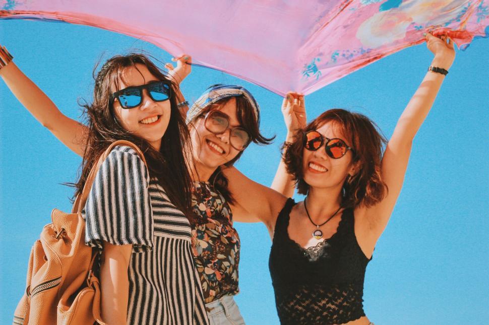 Free Image of Three Women Posing Under Pink Umbrella 