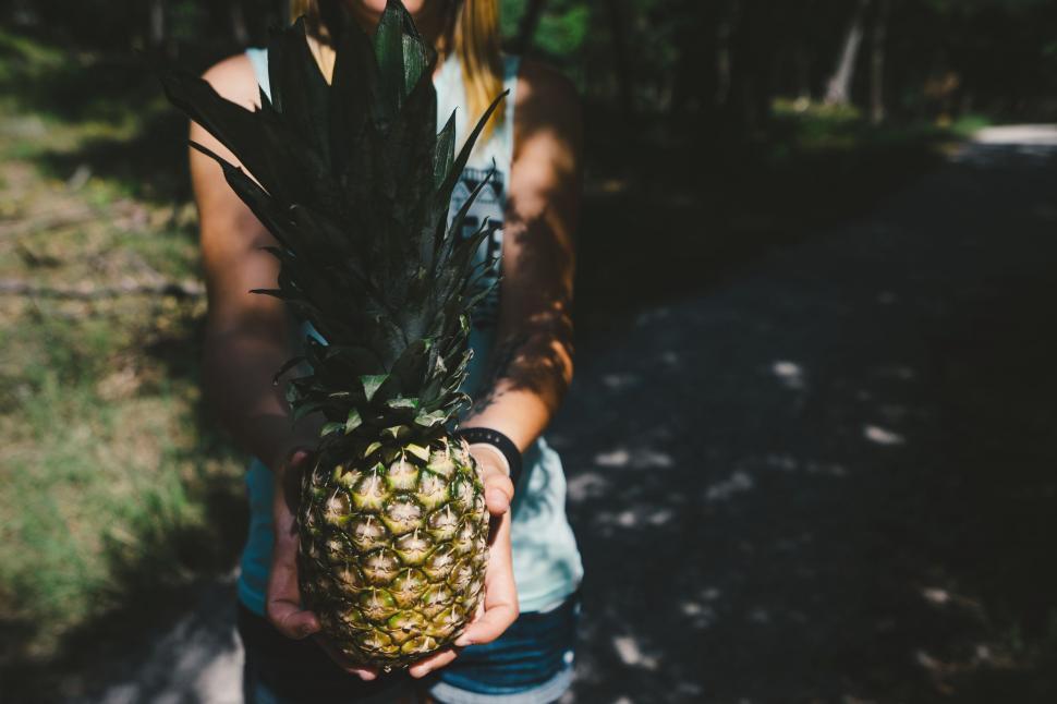 Free Image of Woman Holding a Pineapple in Her Hands 