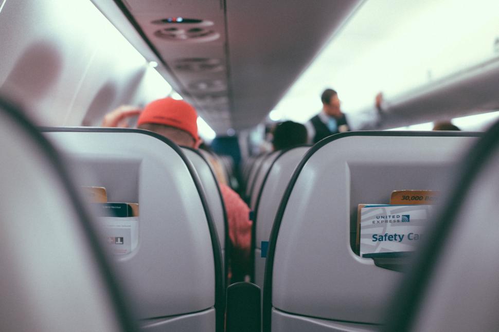 Free Image of Person With Red Hat Sitting on Airplane 