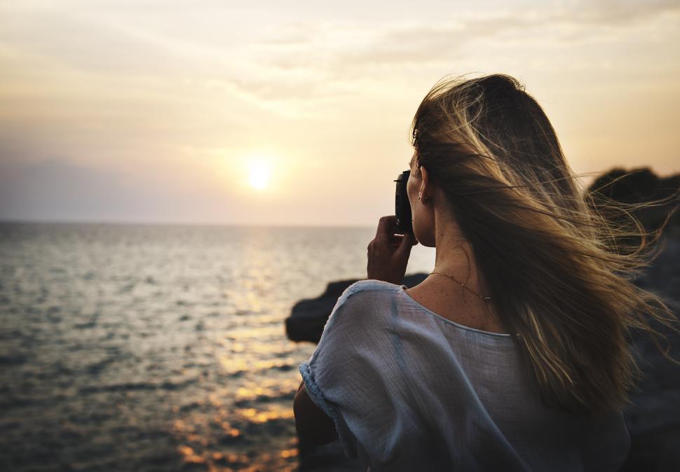 Free Image of Woman on Cell Phone Looking at Ocean 
