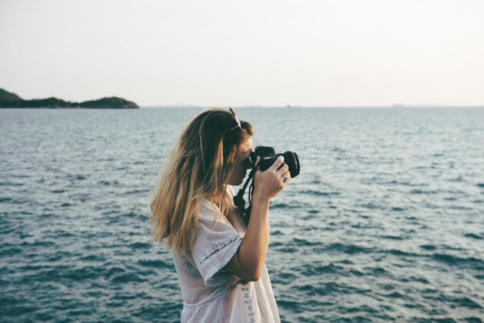 Free Image of Woman Photographing Body of Water 
