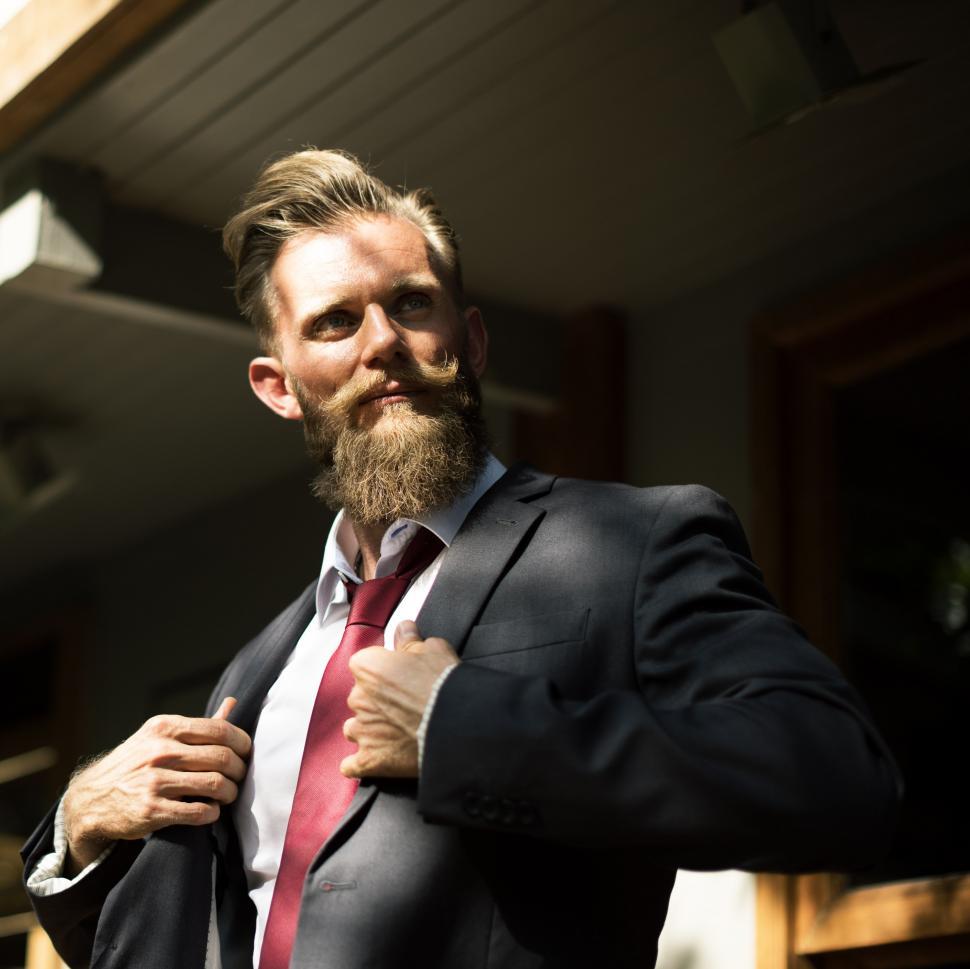 Free Image of Bearded Man in Suit Adjusting Tie 
