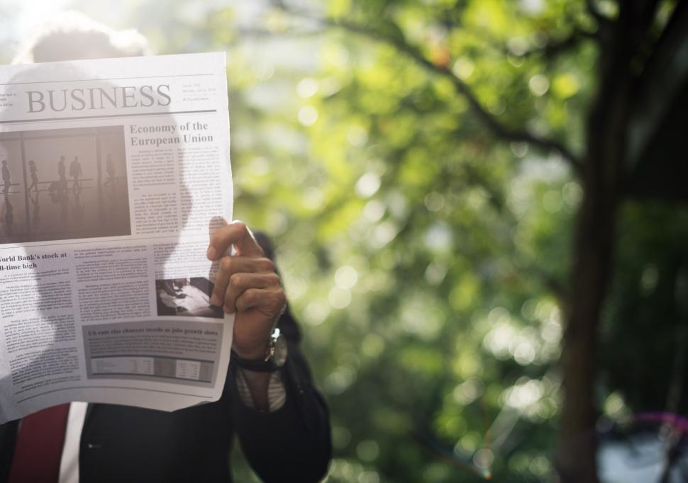 Free Image of Person Holding Newspaper up to Face 