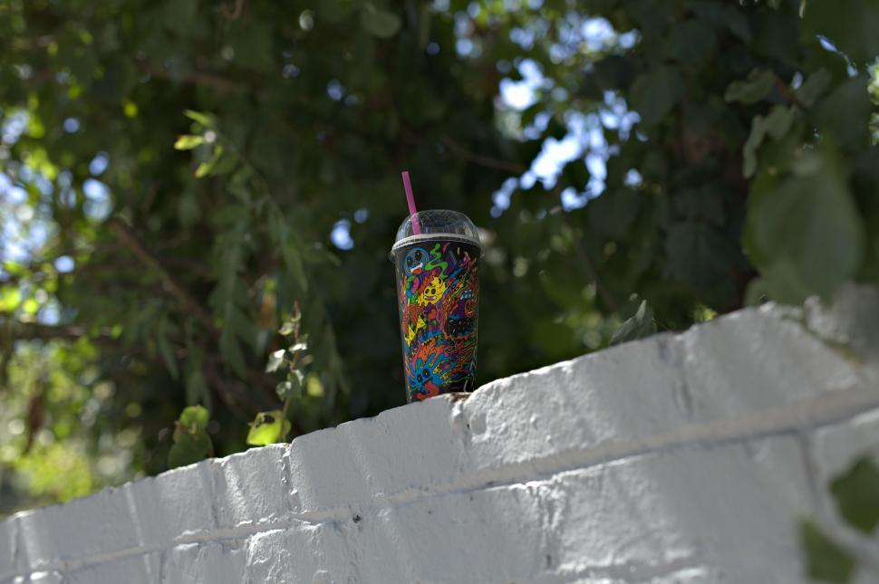 Free Image of Plastic Cup on White Brick Wall 