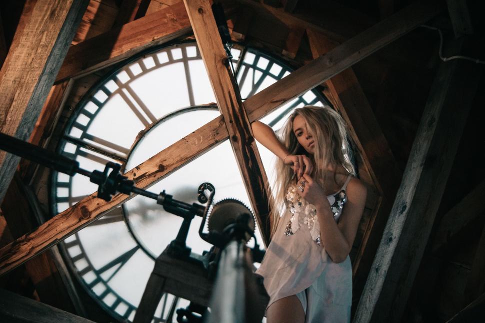 Free Image of Woman Standing in Front of Large Clock 